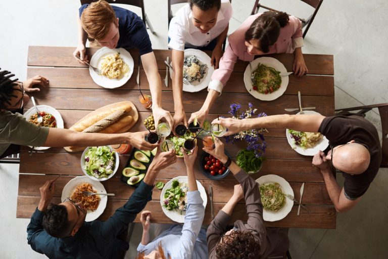 Group of people sitting at a dinner table celebrating a toast