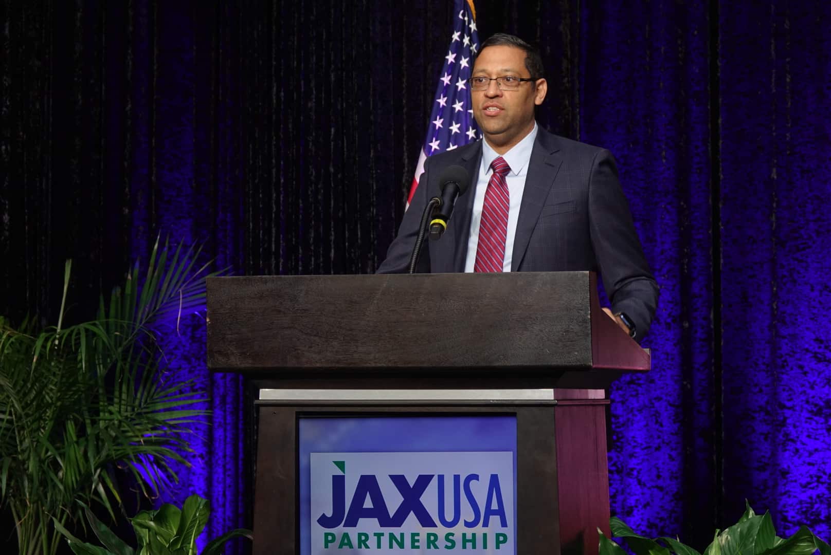 TriageLogic Dr. Ravi Raheja speaks behind a podium about receiving the JaxUSA Innovation Award.