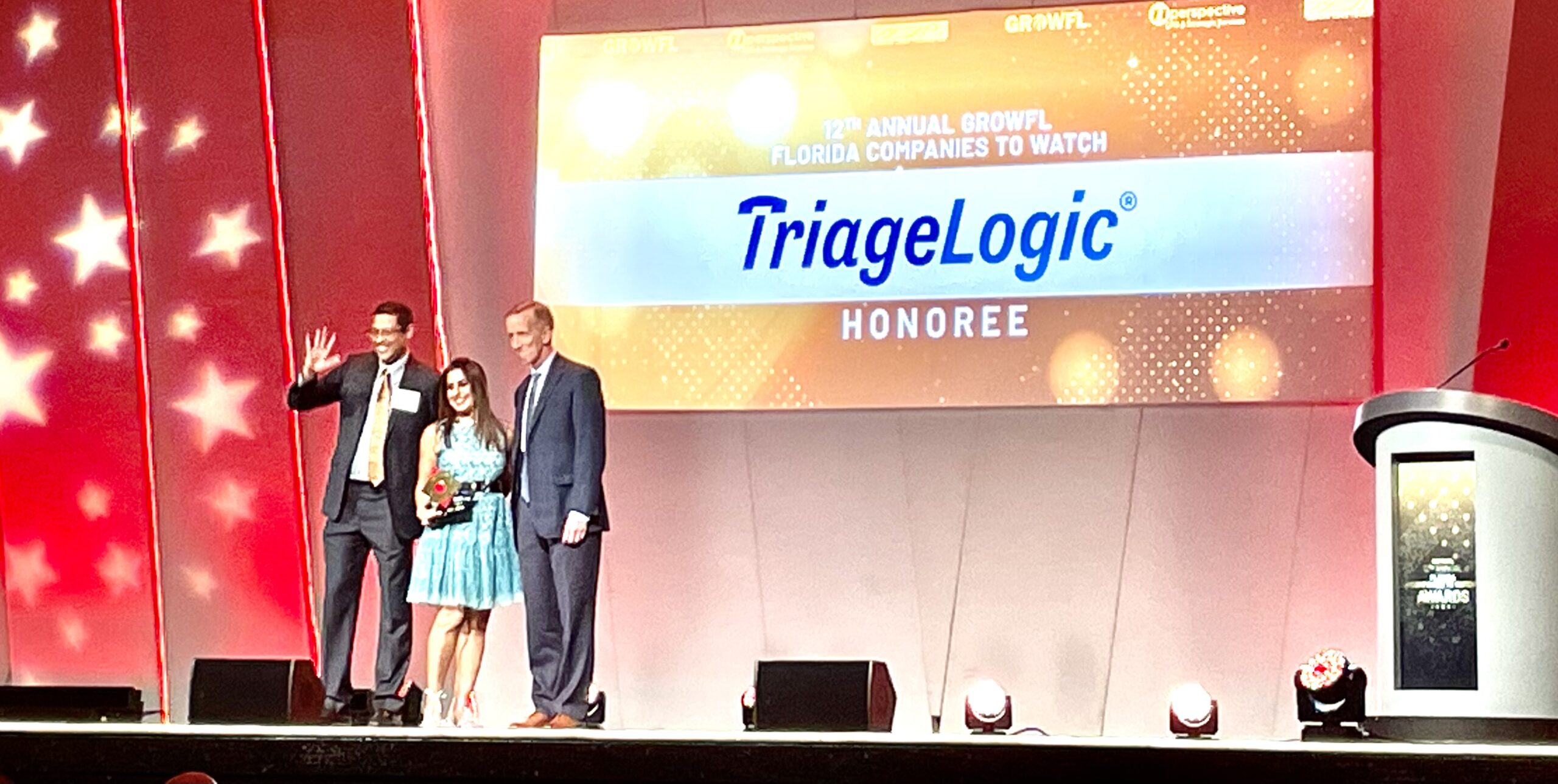TriageLogic Drs. Ravi and Charu Raheja accept an award on stage at GrowFL.