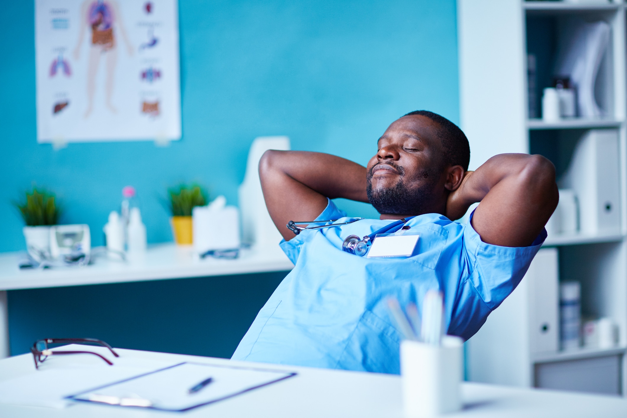 Solutions for Physician Work-Life Balance: A happy physician leans back in his chair in his office, thanks to using nurse triage tools that have given him more time to focus on care.