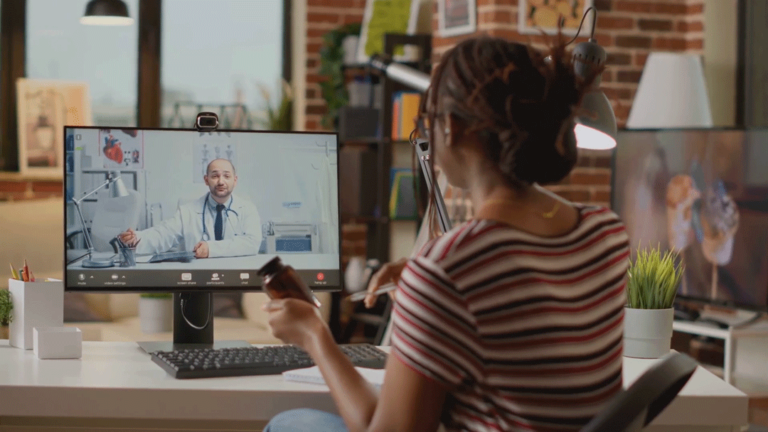 A patient talks with their provider over a telehealth call about their remote patient monitoring device.