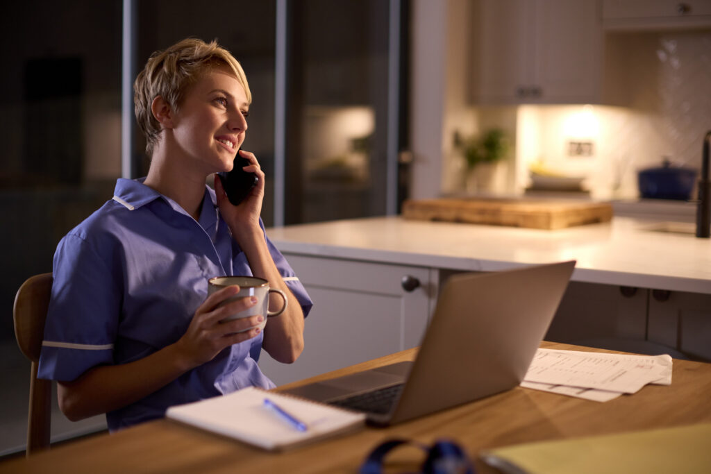 A remote triage nurse works from her office table after normal business hours.