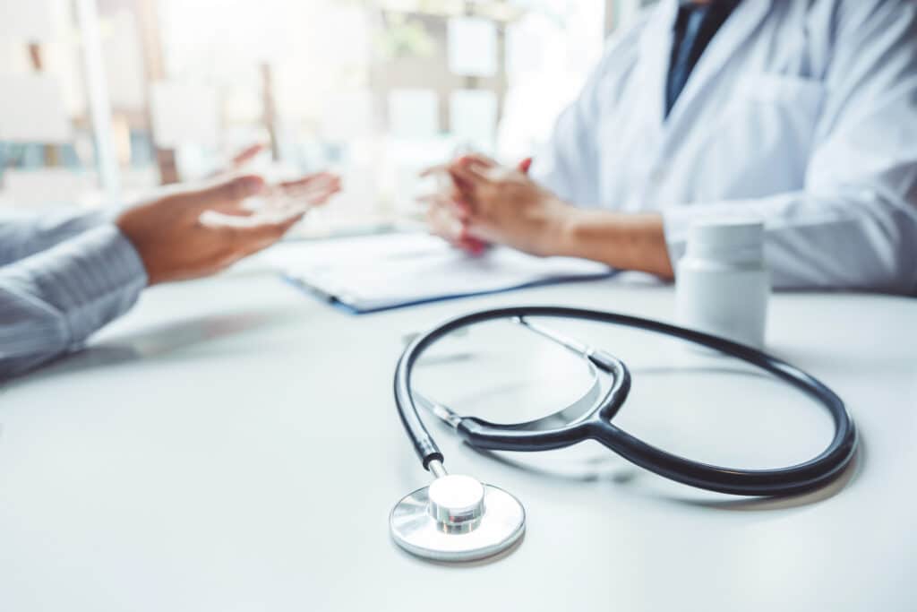 A doctor and patient have a consultation in an office.