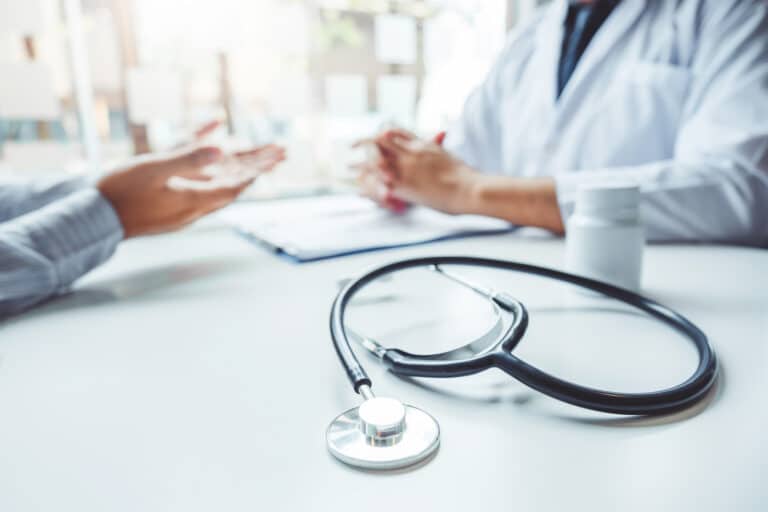 A doctor and patient have a consultation in an office.