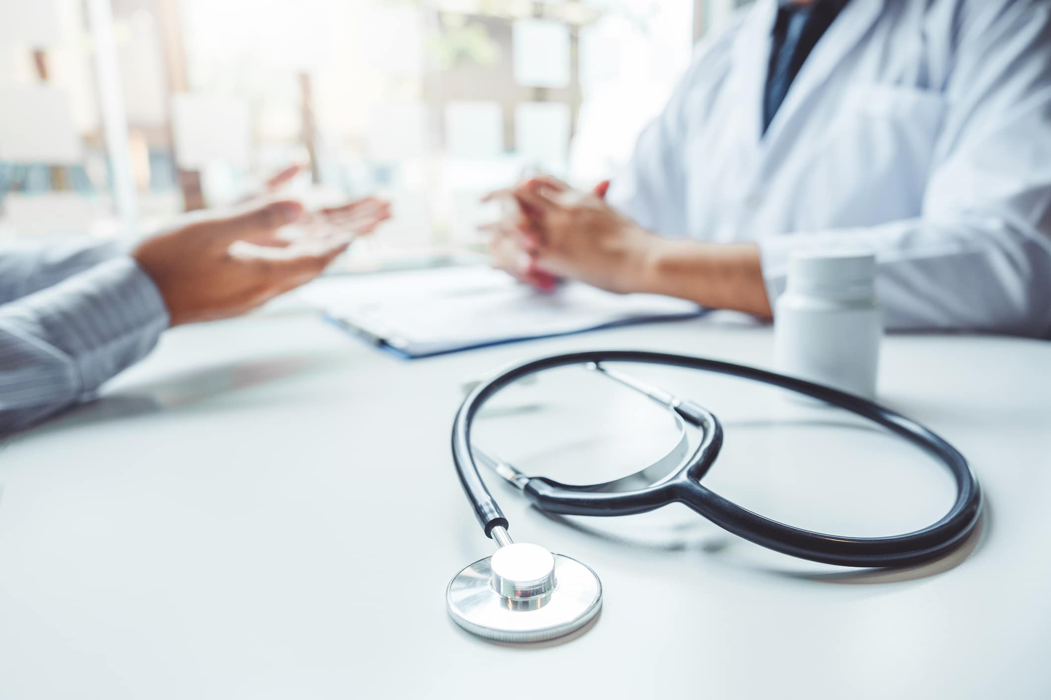 A doctor and patient have a consultation in an office.