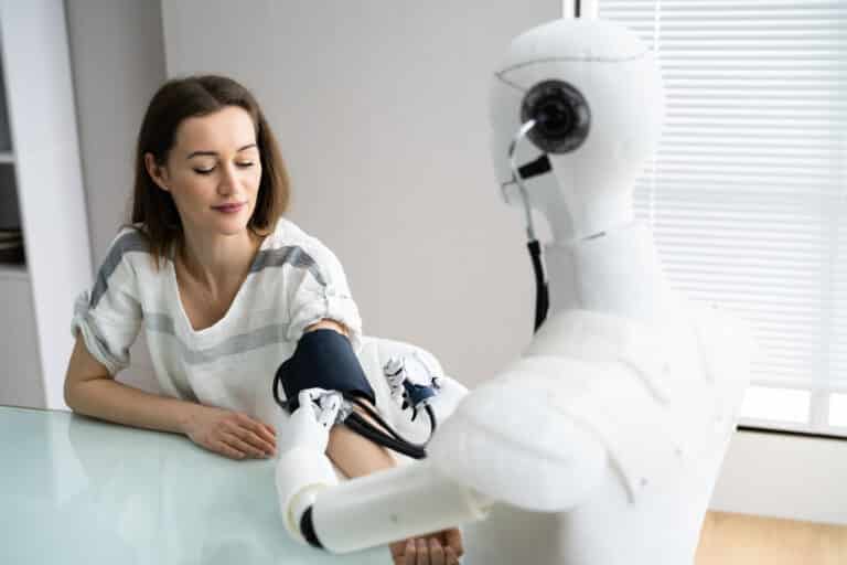 AI in RPM concept: a humanoid robot uses a blood pressure cuff on a woman's arm.