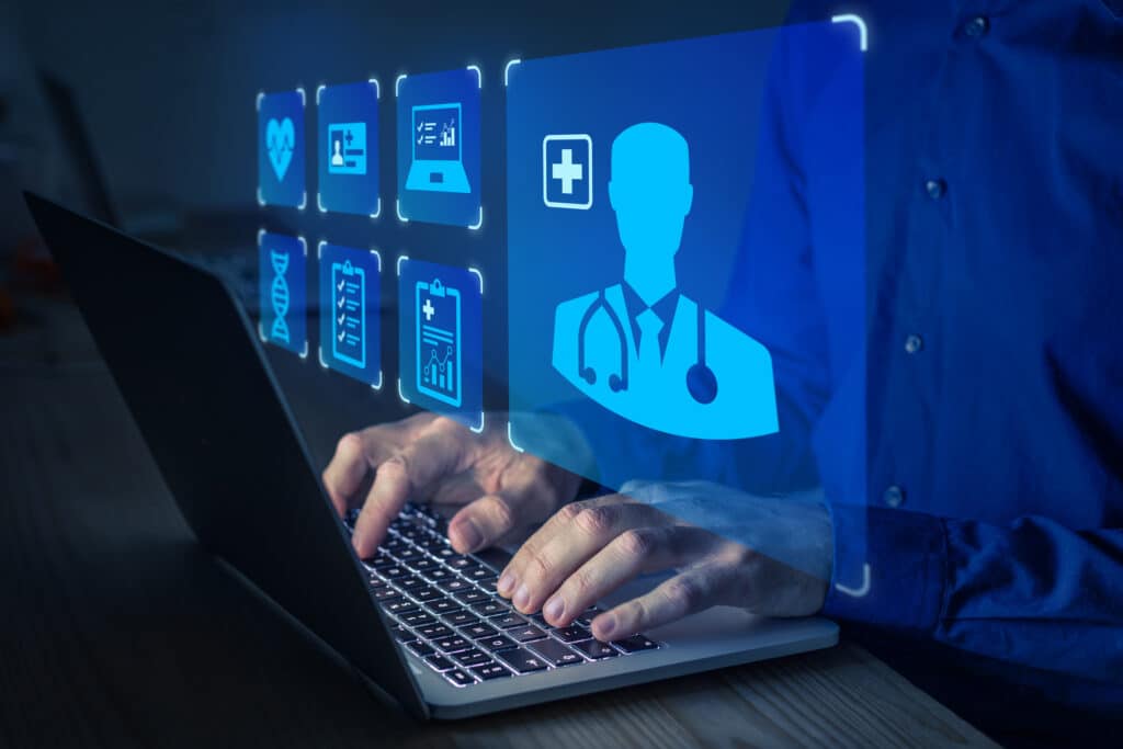 Medical file icons hover above a laptop.