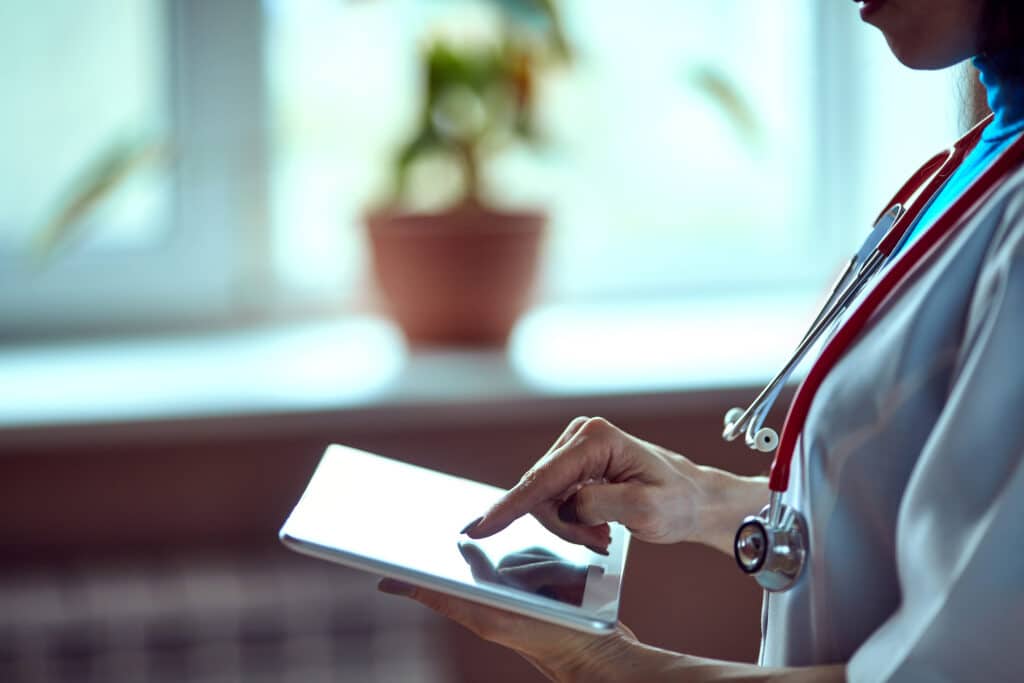 A doctor reviews predicted call volume on a tablet using AI software.
