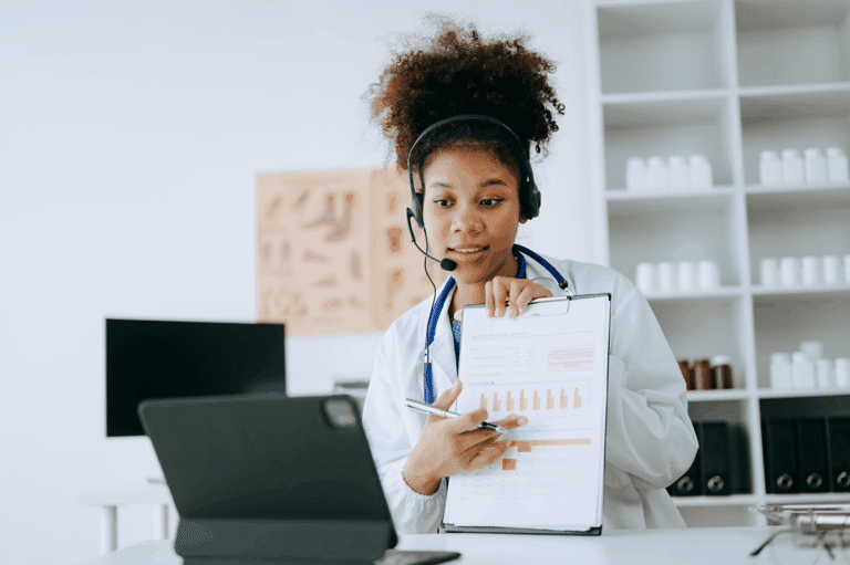 Remote patient monitoring in action: a triage nurse reviews patient health data on a clipboard with a provider over a video call.