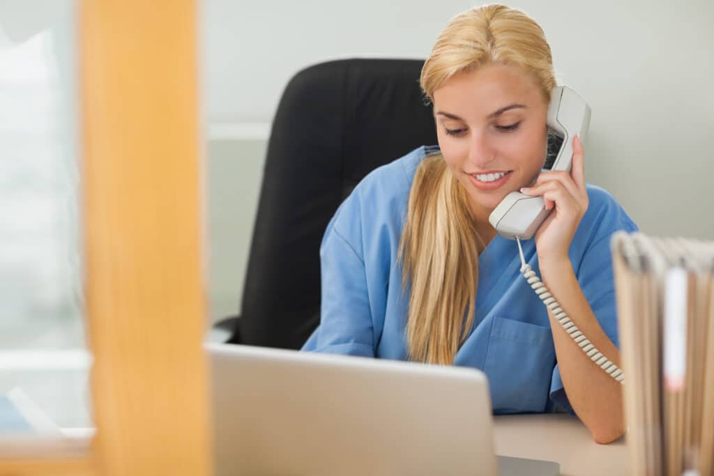 After-hours nurse triage services represented by a nurse answering a phone in the evening for a medical practice.