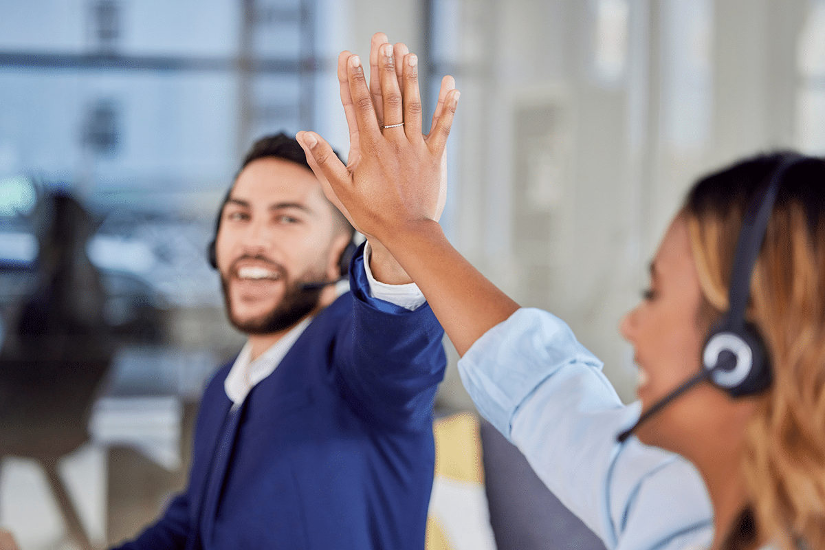Two nurses in a call center high-five.