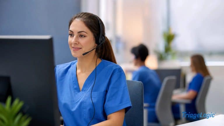 Registered nurse wearing a headset conducting a patient triage call at a professional clinical workstation.