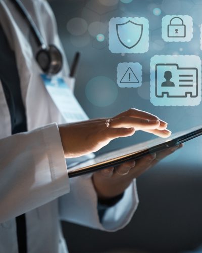 A clinician uses a tablet to check medical intake and secure messages. Icons representing a patient file hover above the tablet.