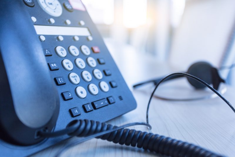 Patient care represented by headphones and office phone for a triage nurse.