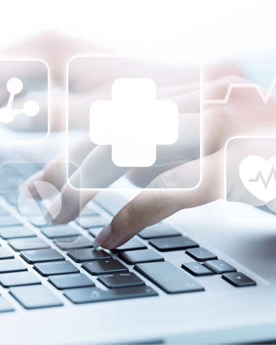 A nurse uses triage software while healthcare icons hover above a laptop keyboard.