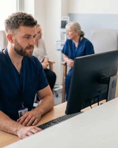 Emergency department triage nurse reviewing patient acuity data at a workstation, illustrating the five levels of triage in practice